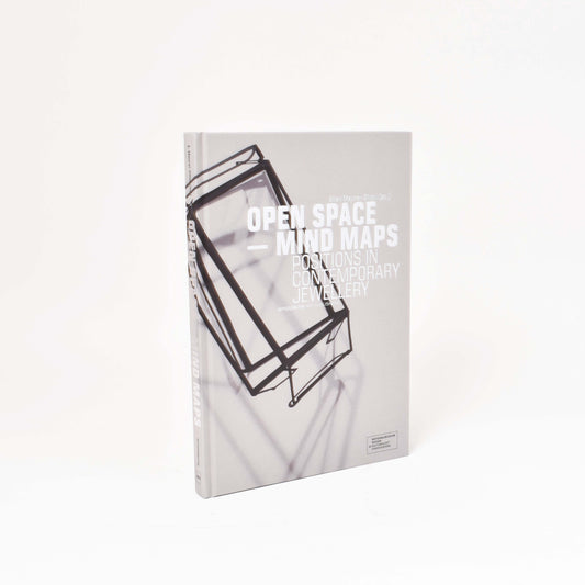 Framsida till boken open-space mind maps med grått omslag med smycke