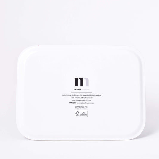 Vit baksida av rektangulär bricka med motiv av Carl Larssons Frukost under stora björken