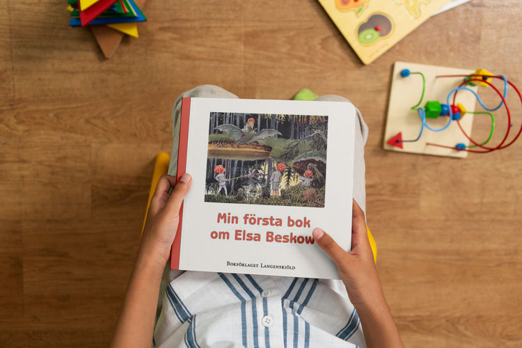 barn som håller i boken Min första bok om Elsa Beskow