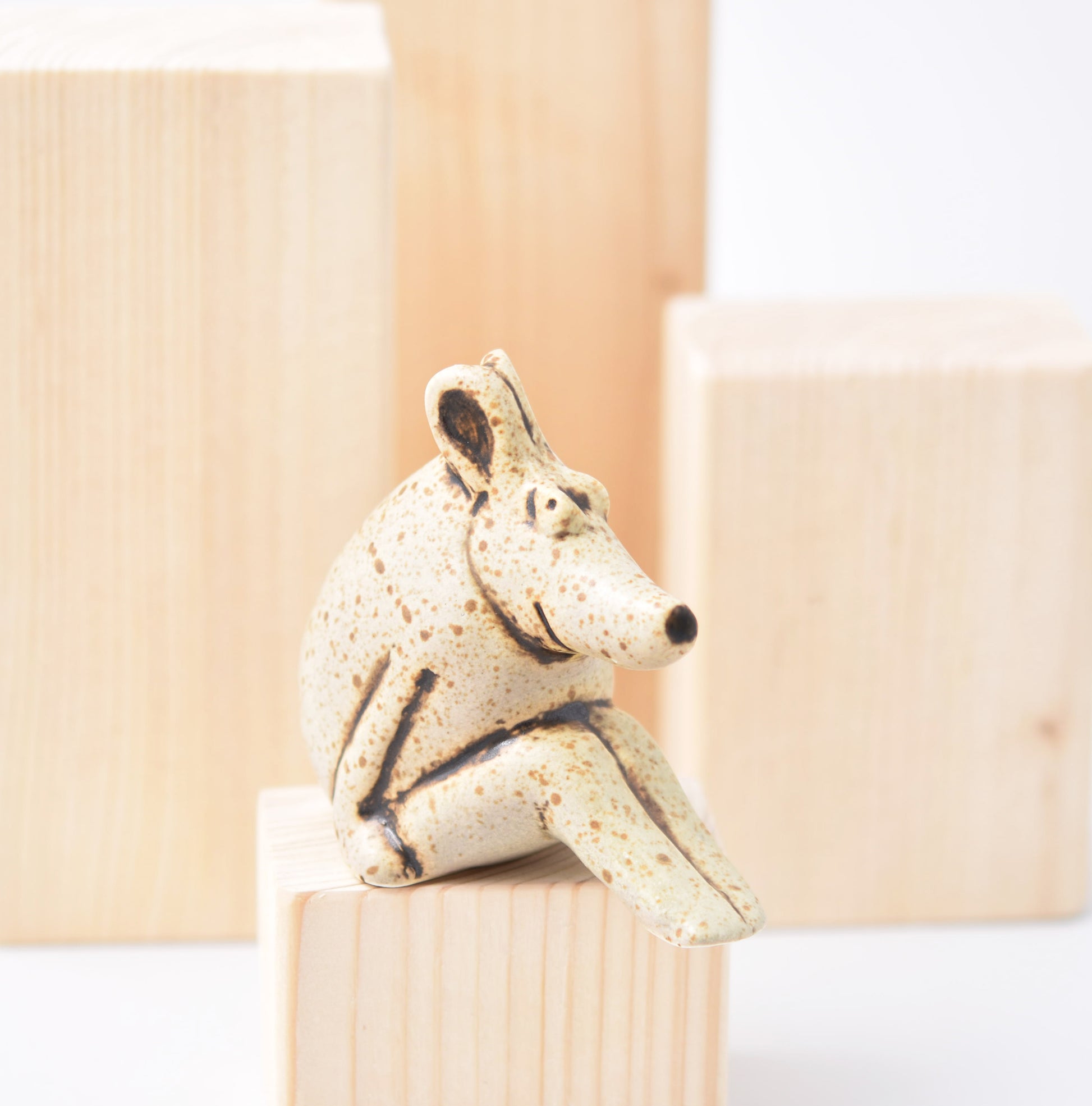 Sittande figurin av Lisa Larson i bruna och grå nyanser