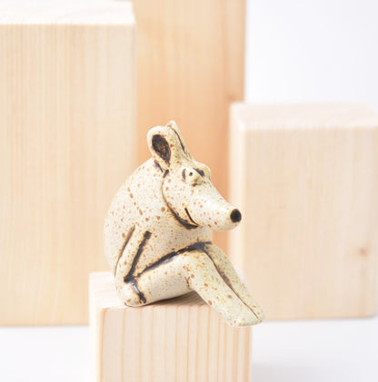 Sittande figurin av Lisa Larson i bruna och grå nyanser