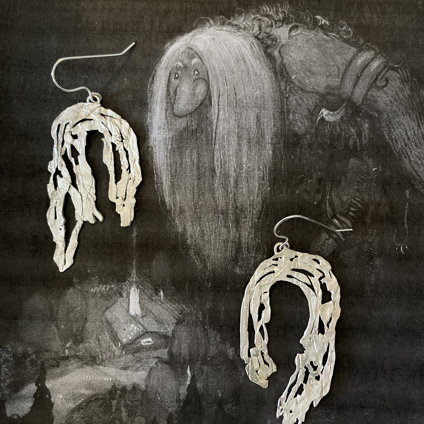 örhängen i silver och bild av John Bauers troll från Nationalmuseum