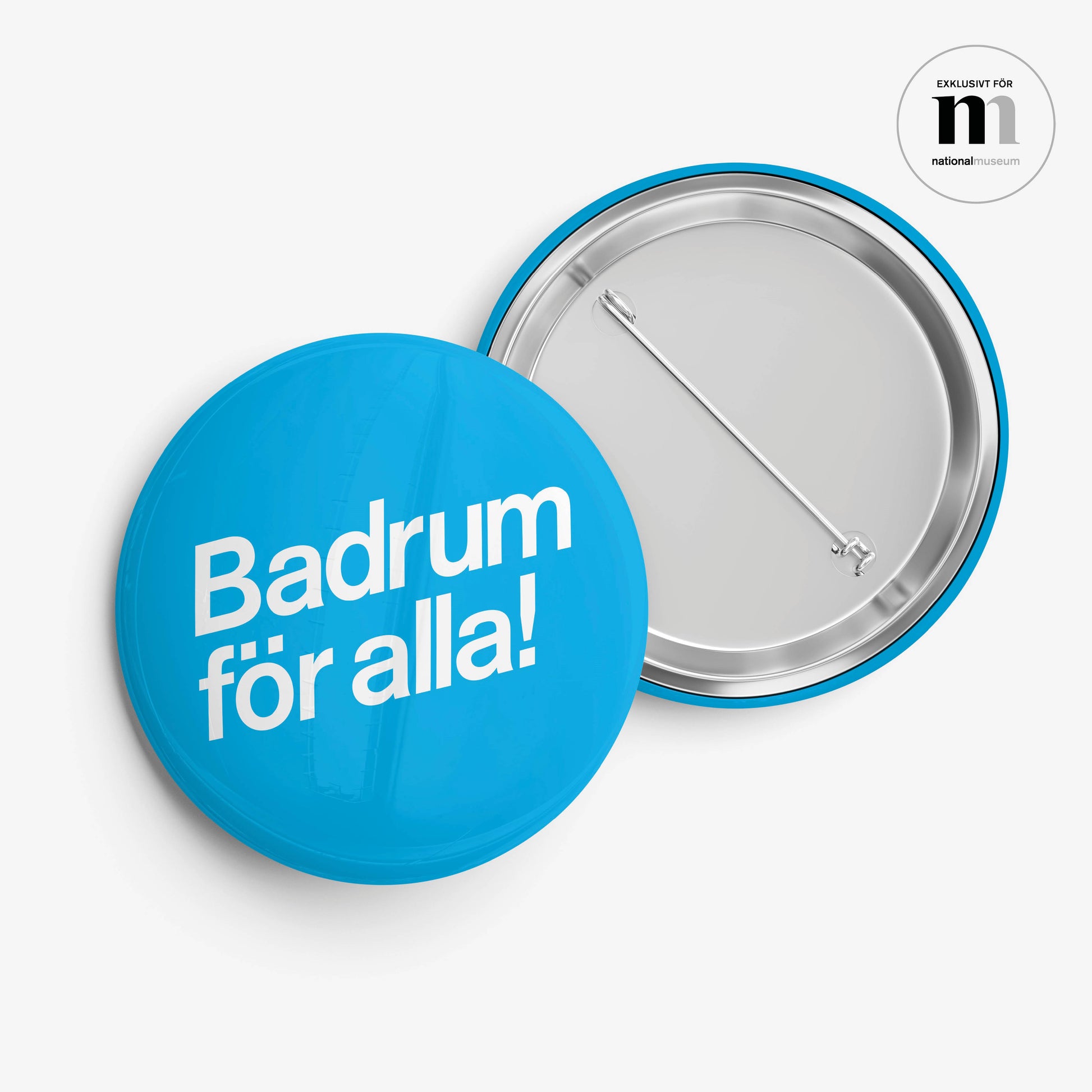 Rund badge med nål på baksidan i blått med vit logga från utställningen Badrum för alla