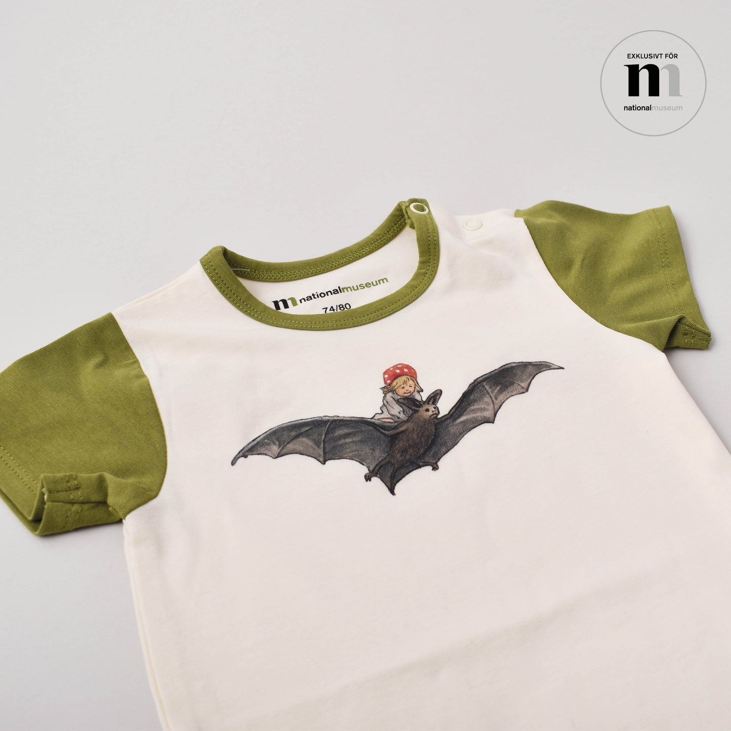 grön och beige babybody med motiv från Elsa Beskows tomtebobarnen från Nationalmuseum