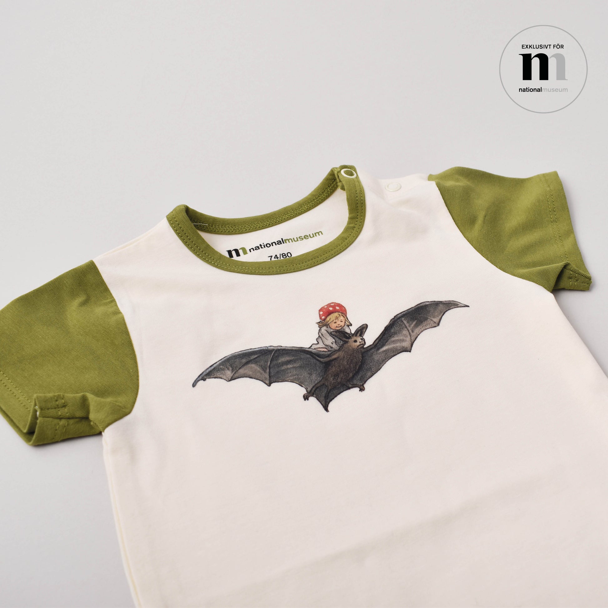 grön och beige babybody med motiv från Elsa Beskows tomtebobarnen från Nationalmuseum