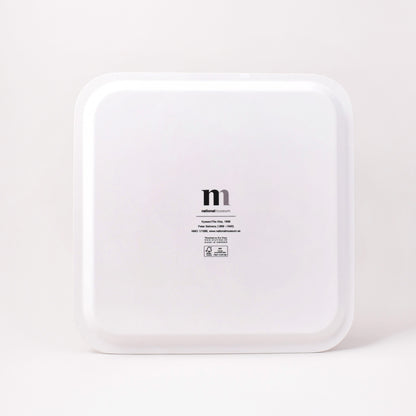 baksida av brickan kyssen med titel på konstverket och logga från Nationalmuseum