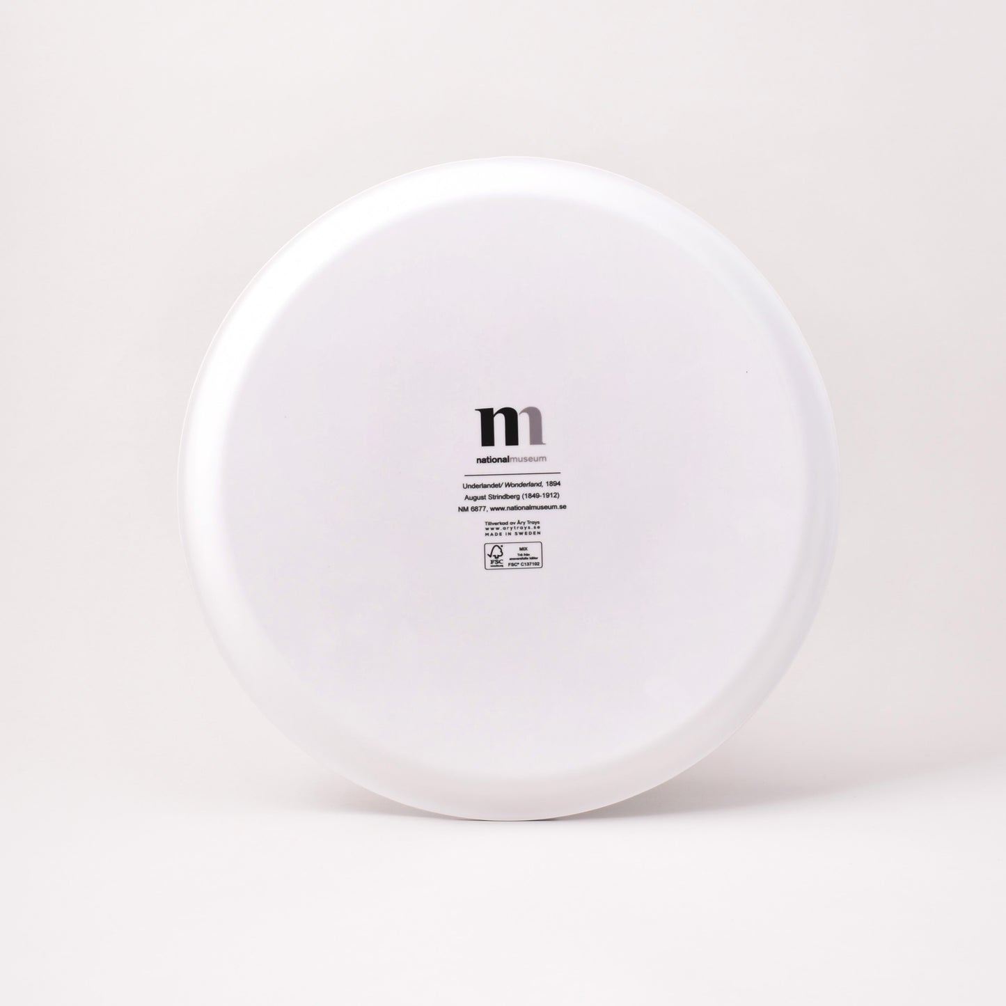 Baksida av brickan Underlandet i vitt med Nationalmuseums logga