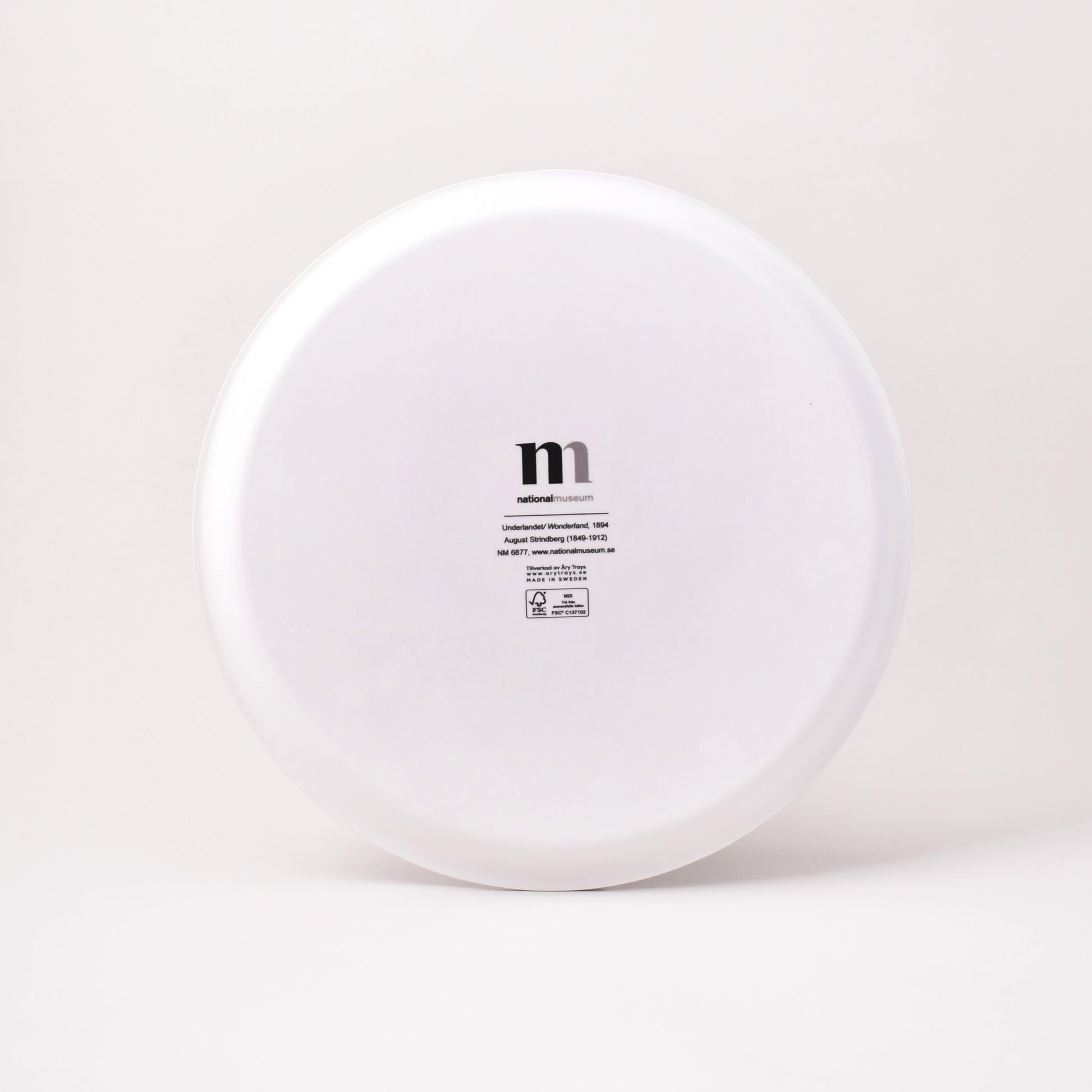 Baksida av brickan Underlandet i vitt med Nationalmuseums logga