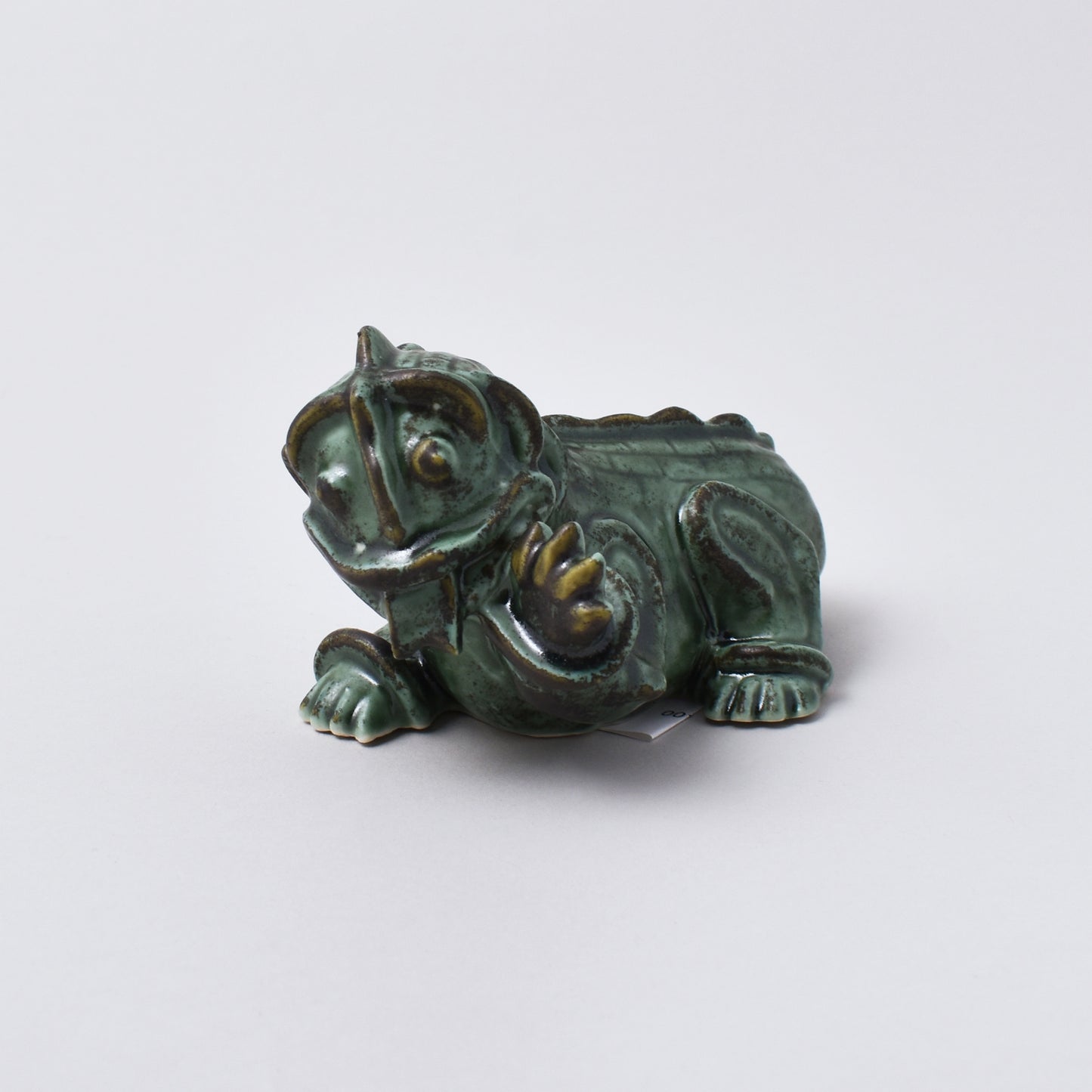 Keramikfigurinen Inez i grön glasyr från Wilhelm Kåges kollektion Drakvalpar i Nationalmuseum shop