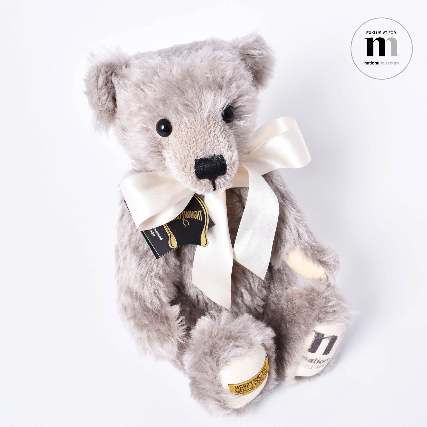 Exklusiv grå och mjuk nalle med vit rosett från Nationalmuseum