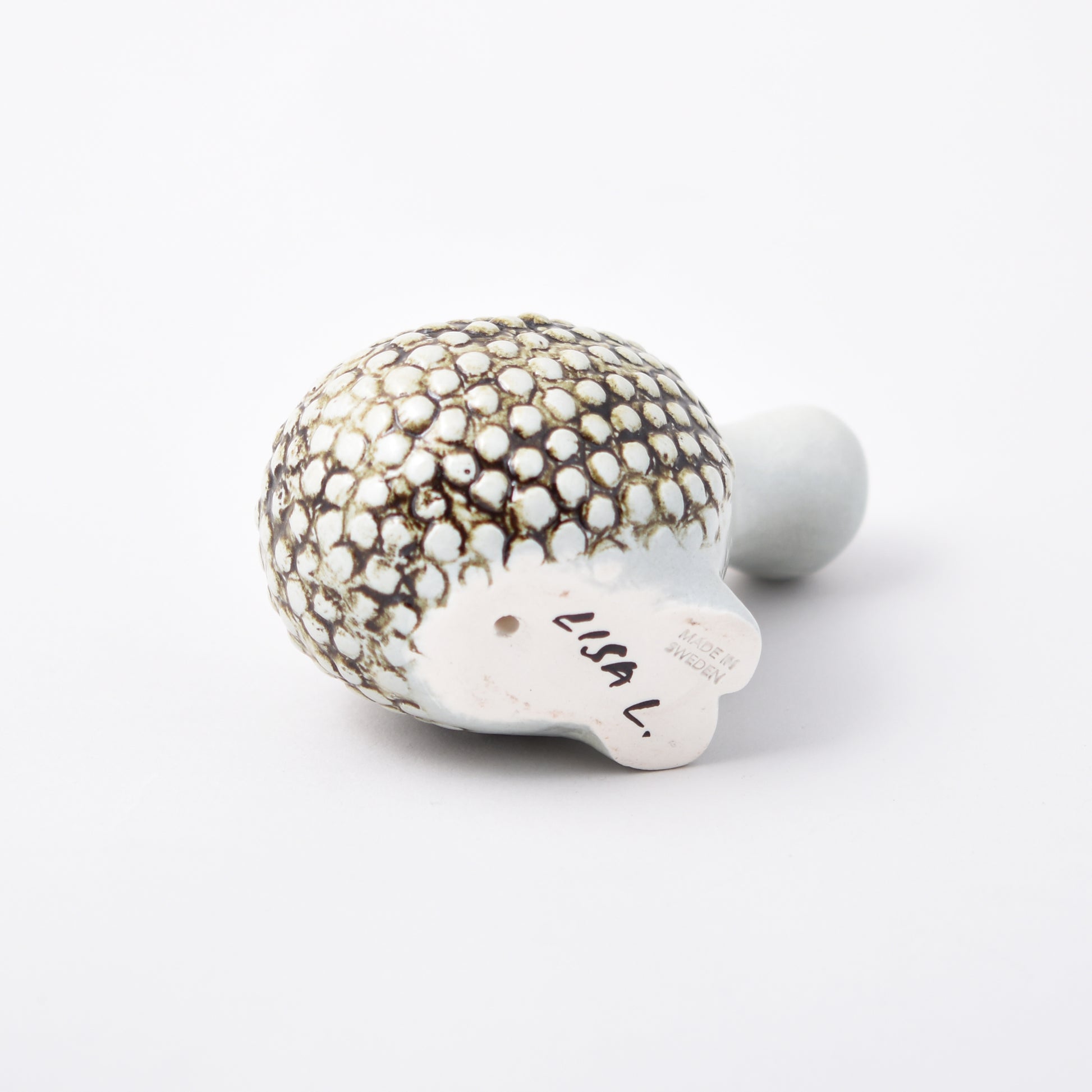 Signatur av Lisa Larson på figuren Olivia från serien Okända djur