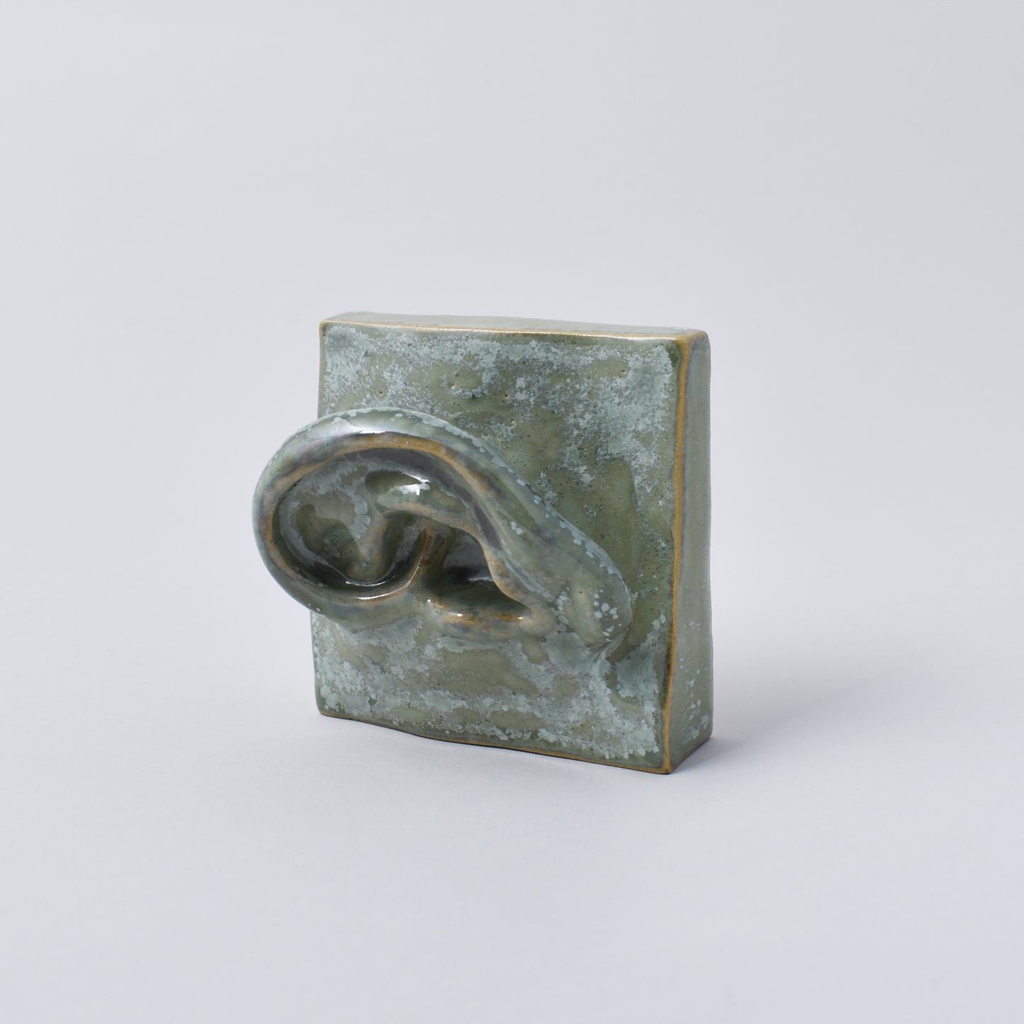 liten handgjord skulptur i grön nyans som föreställer ett öra i Nationalmuseum shop