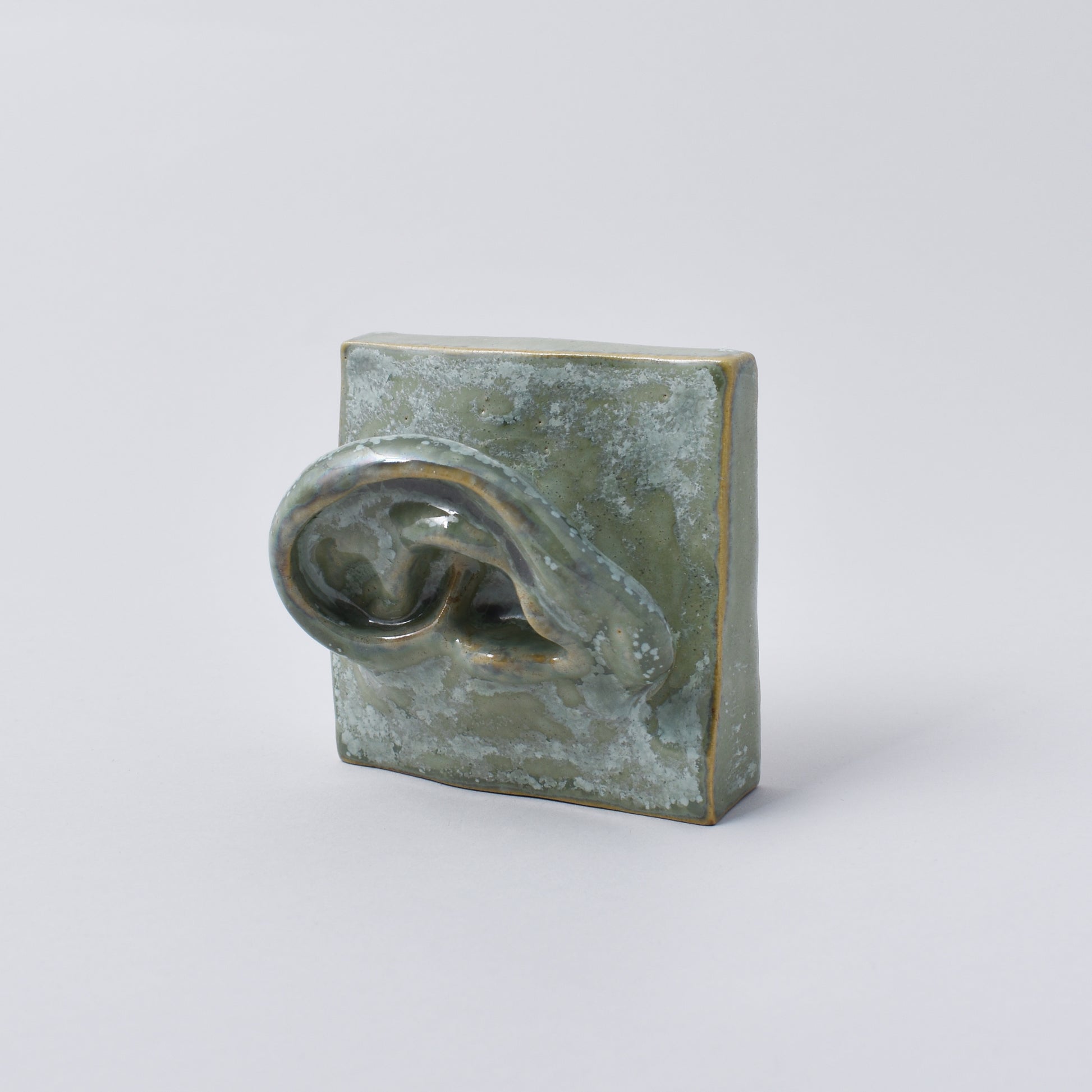 liten handgjord skulptur i grön nyans som föreställer ett öra i Nationalmuseum shop