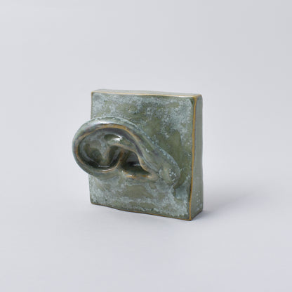 liten handgjord skulptur i grön nyans som föreställer ett öra i Nationalmuseum shop
