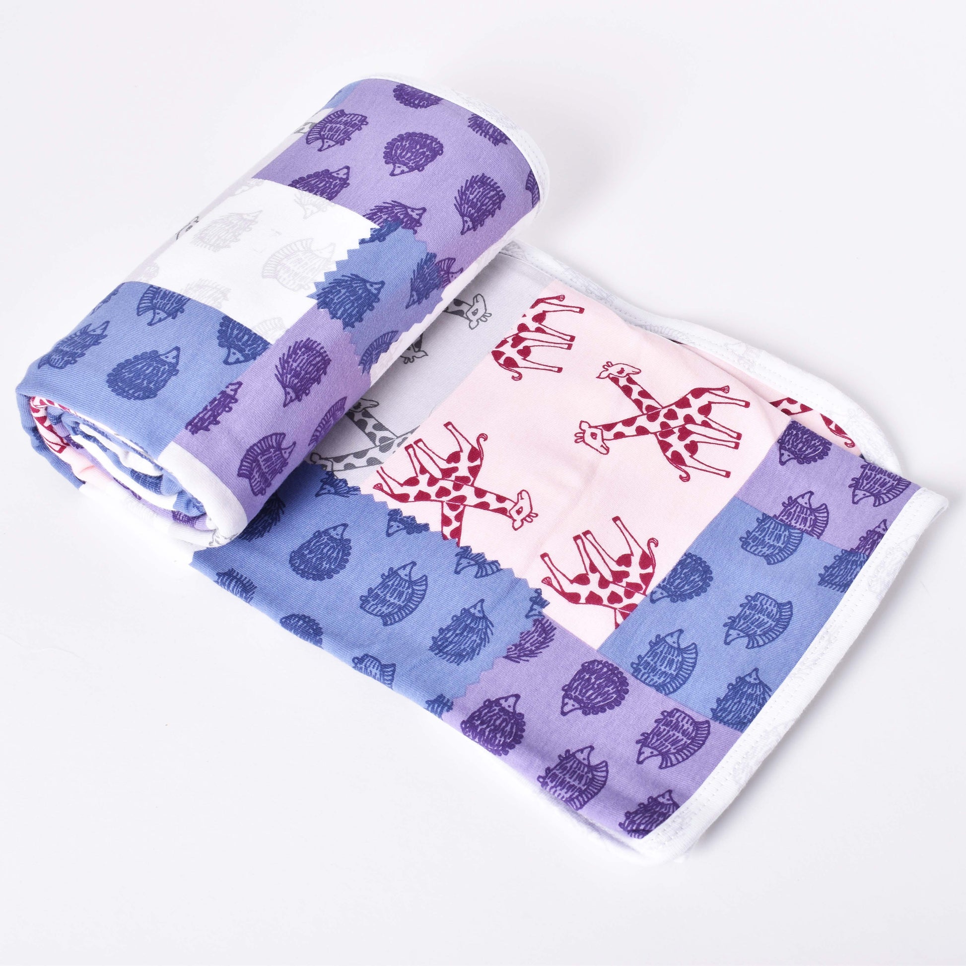 Flerfärgad babyfilt med motiv av igelkottar och giraffer i mönsterdesign av Lisa Larson