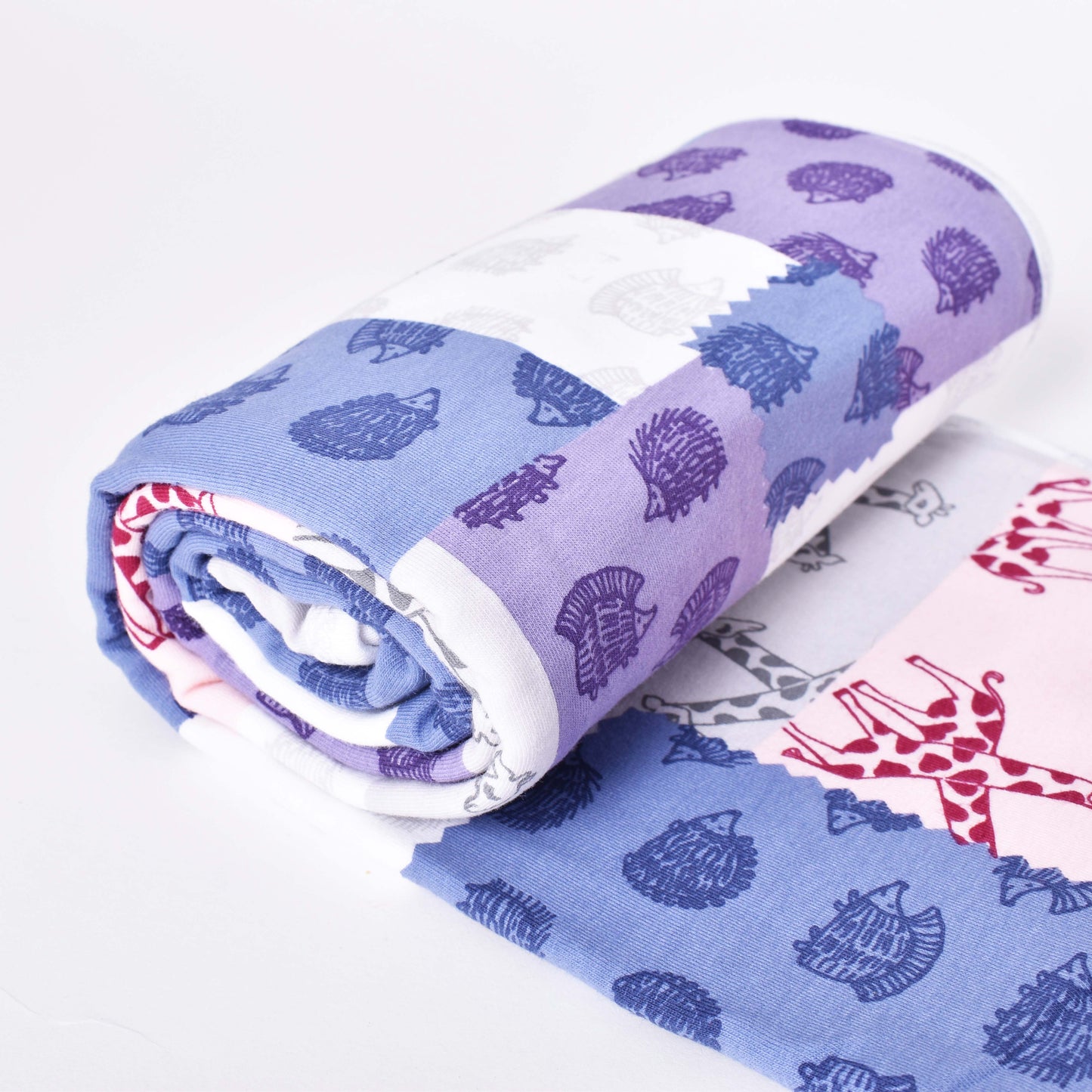 Flerfärgad babyfilt med motiv av igelkottar och giraffer i mönsterdesign av Lisa Larson