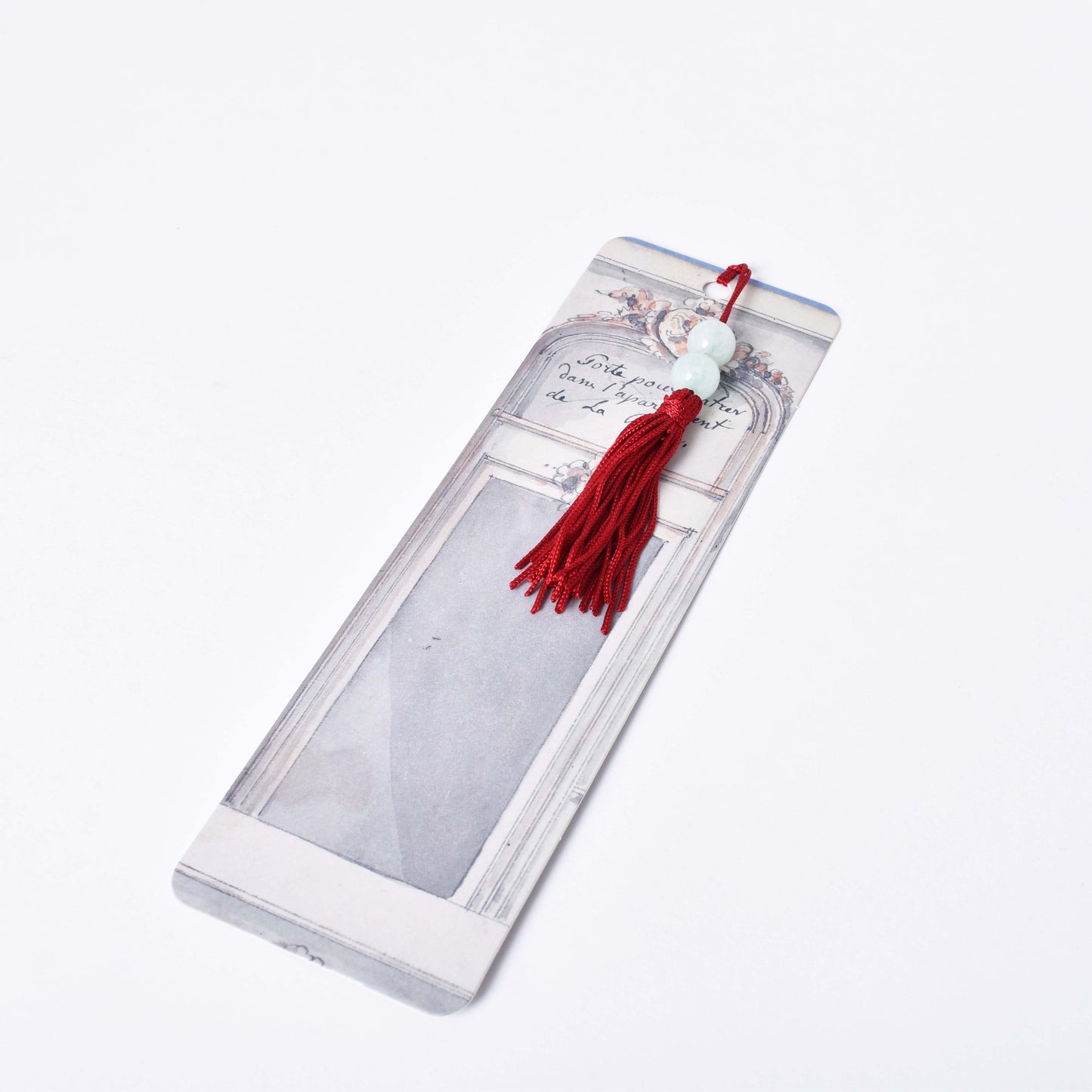 Bokmärke med motiv av skiss på tavelhängning med en röd tofs