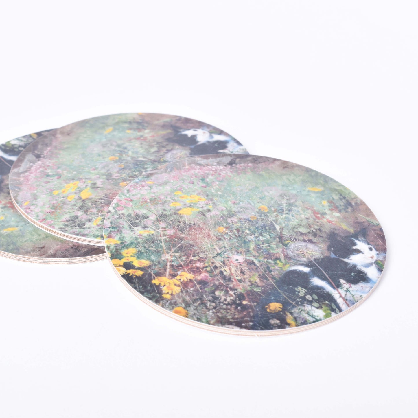 Tre runda glasunderlägg med motiv av Bruno Liljefors Katt på blomsteräng