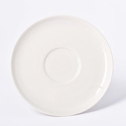 Runt sandfärgat fat till kopp med NM& monogram ingraverat i kanten i design av Carina Seth Andersson