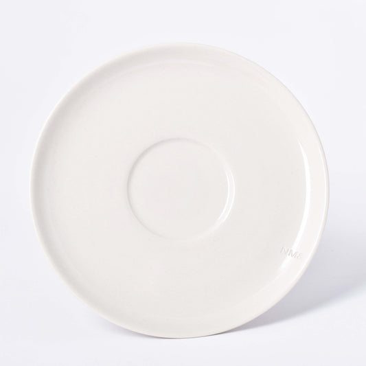 Runt sandfärgat fat till kopp med NM& monogram ingraverat i kanten i design av Carina Seth Andersson