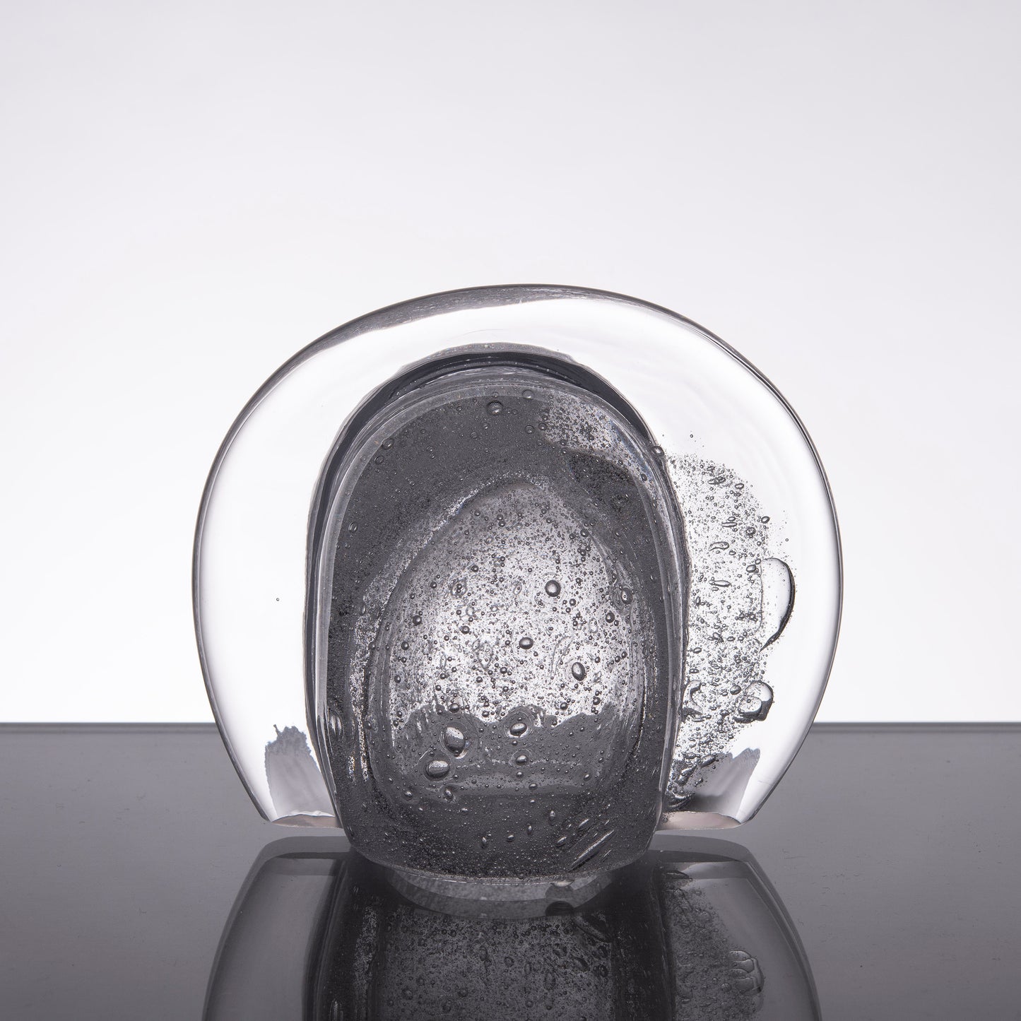 Ljuslykta till bordet av klart glas med små bubblor i