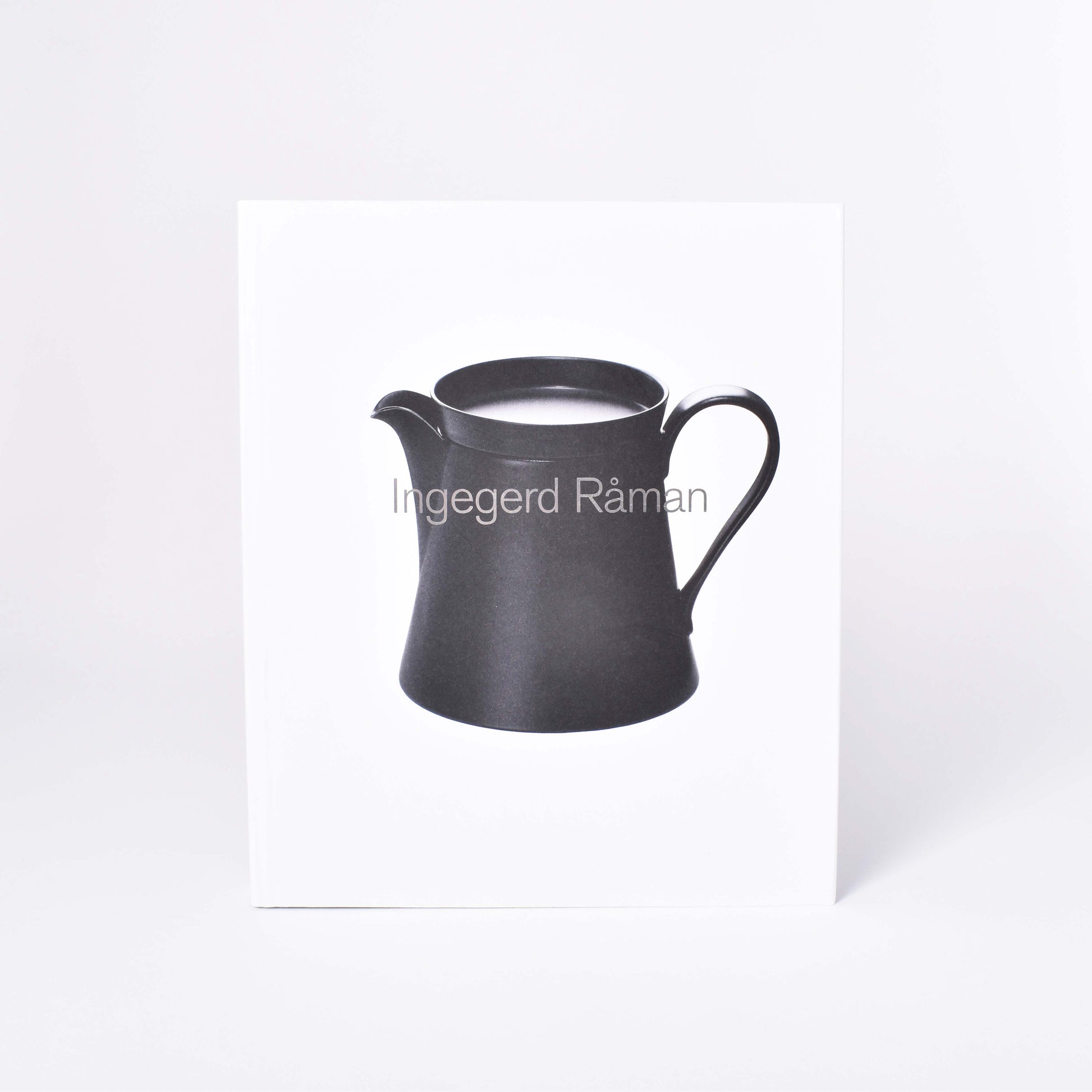 Framsida till boken Ingegerd Råman med svart kanna på vit bakgrund