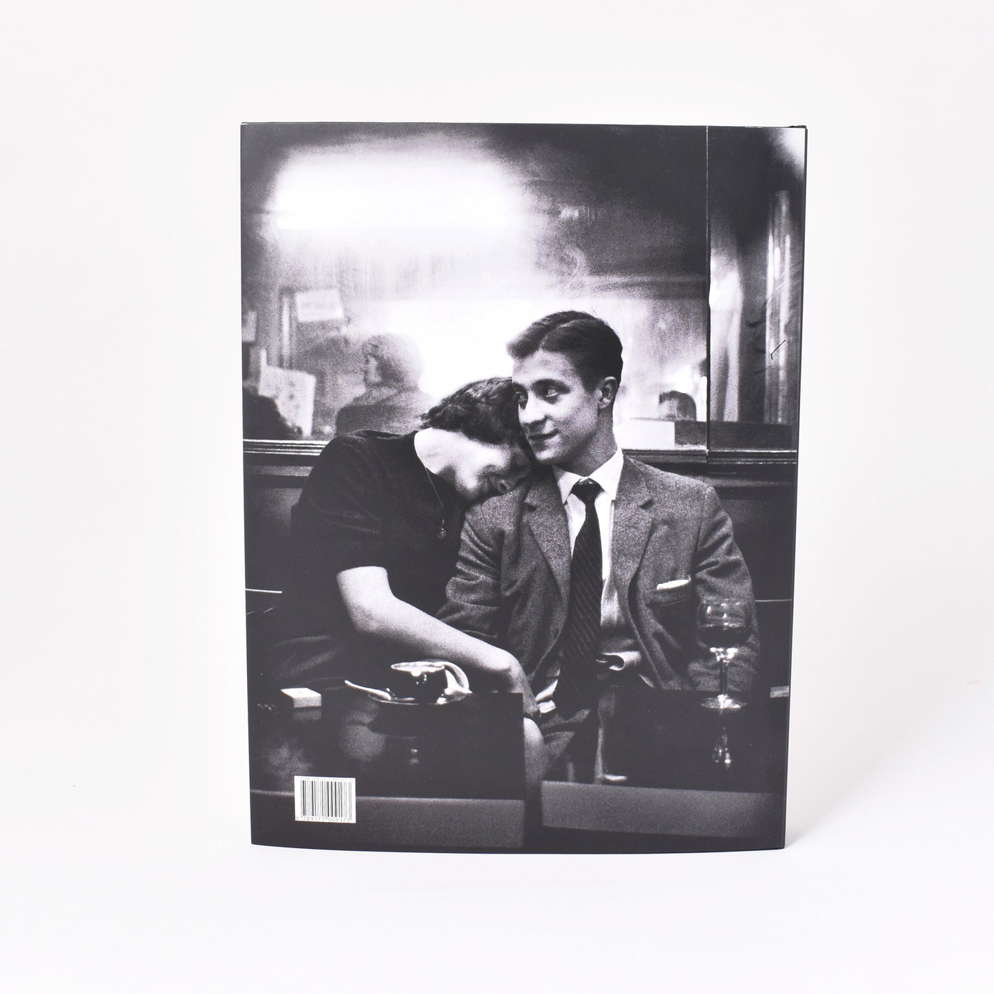 Baksida till utställningskatalogen från NAtionalmuseum om Christer Strömholm med svartvitt fotografi av ett par i en bar