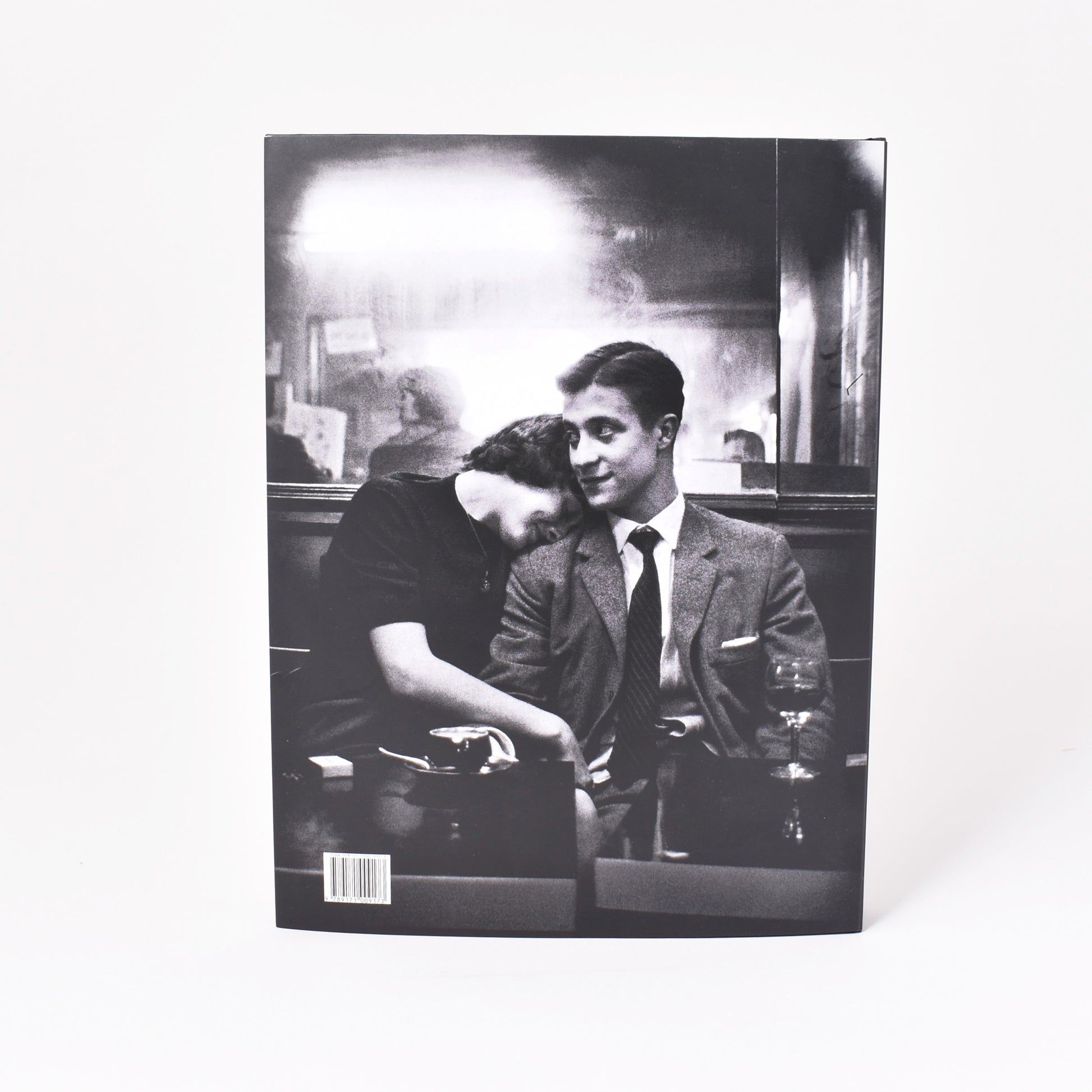 Baksida till utställningskatalogen från NAtionalmuseum om Christer Strömholm med svartvitt fotografi av ett par i en bar