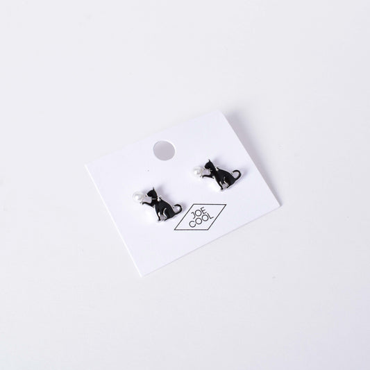 Örhängen med en svart katt omsluten av silverfärgad kant samt med en vit pärla