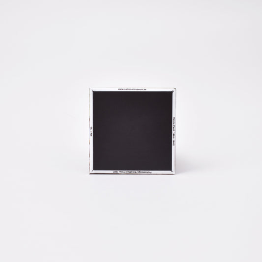 Baksida av kvadratisk magnet med titeln på konstverket frukostdags