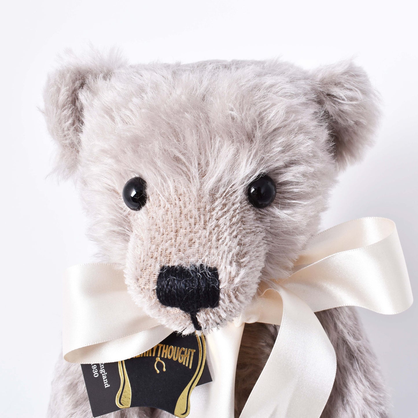 Exklusiv grå och mjuk nalle med vit rosett