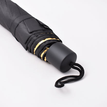 svart teleskopiskt paraply med guld på insidan