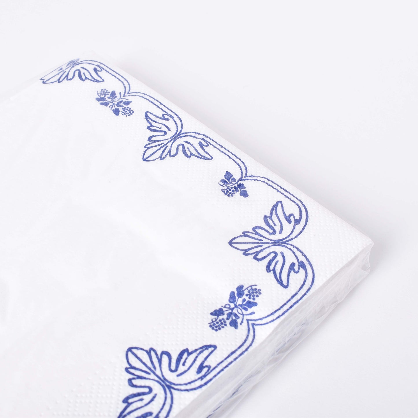 Servetter med mönster av blå druvklasar mot vit botten