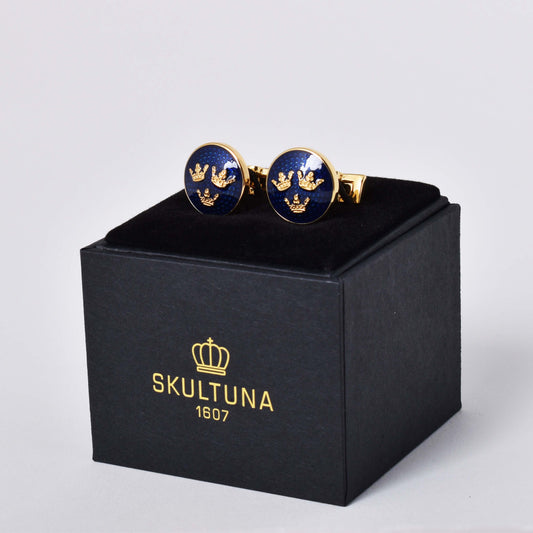 Skultuna manschettknappar med guldpläterad dekor av en variant av riksvapnet Tre Kronor mot kungsblå emalj