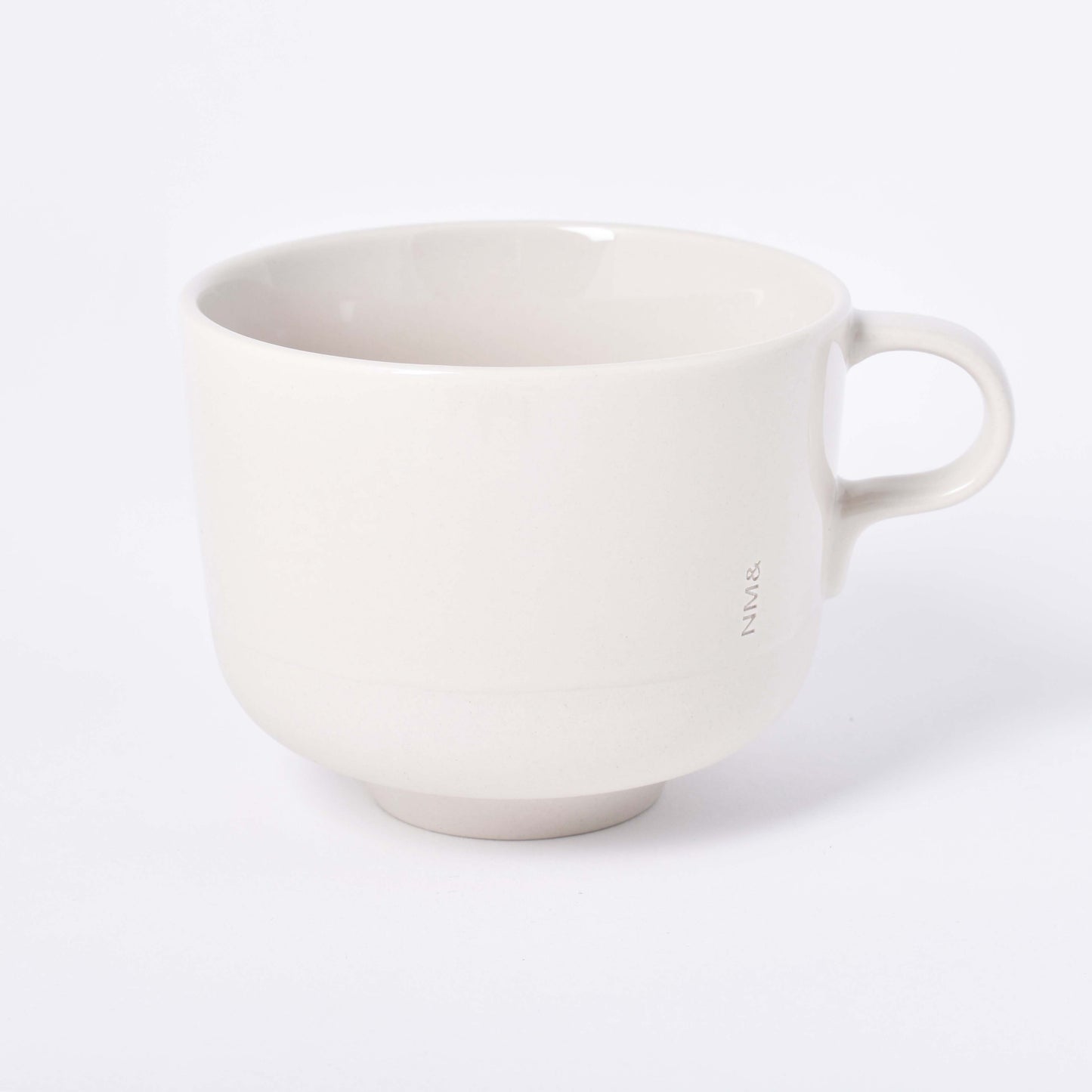 Sandfärgad tekopp med öra och ingraverat NM& monogram i design av Carina Seth Andersson