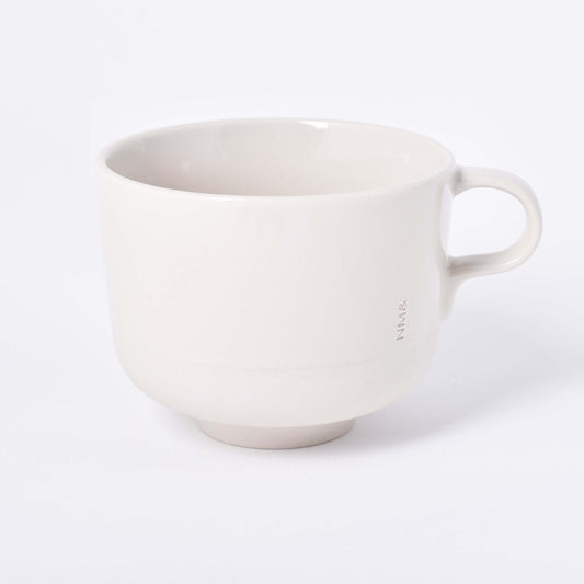 Sandfärgad tekopp med öra och ingraverat NM& monogram i design av Carina Seth Andersson